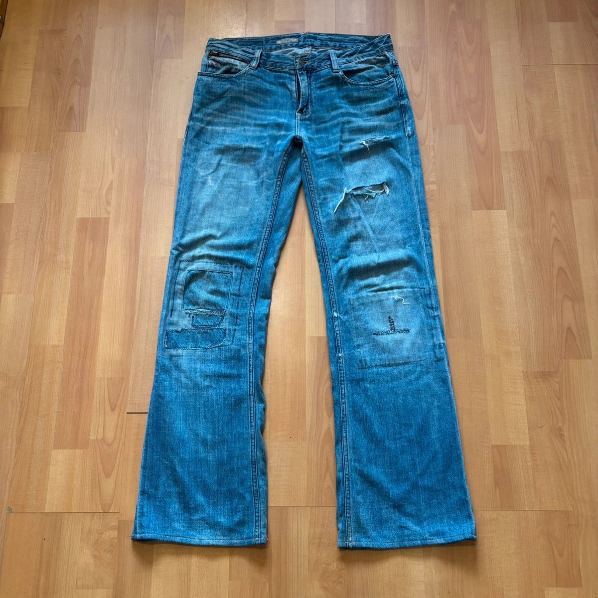 Ralph Lauren blue bootcut jeans with patchwork details and custom "RL" embroidery.