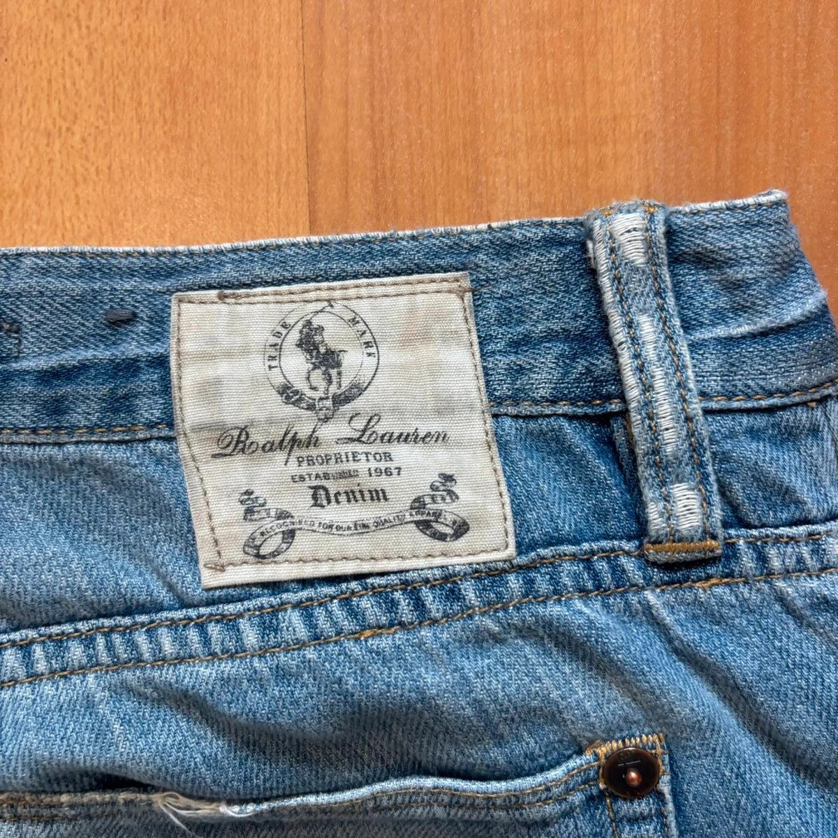 Ralph Lauren blue bootcut jeans with patchwork details and custom "RL" embroidery.