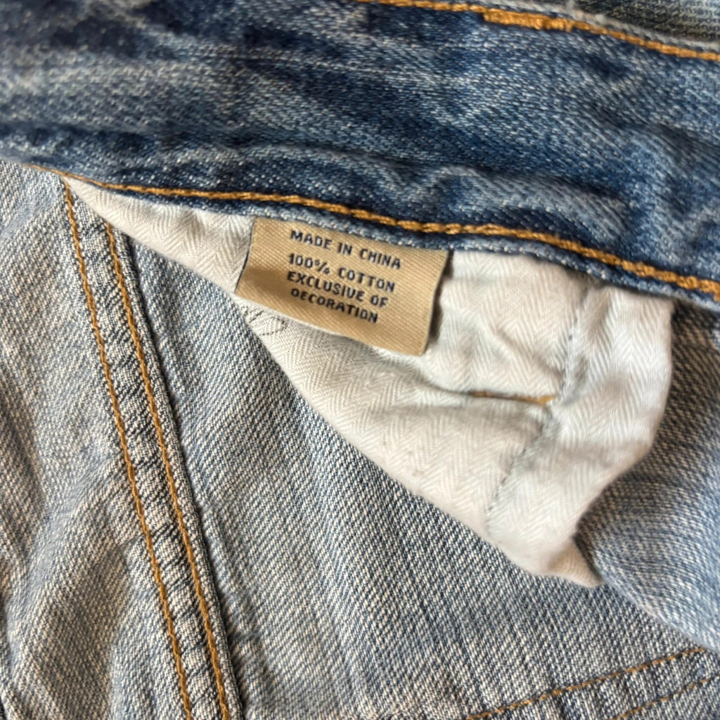 Ralph Lauren blue bootcut jeans with patchwork details and custom "RL" embroidery.