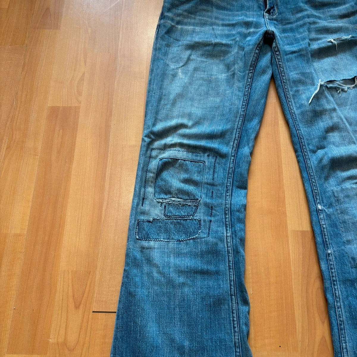 Ralph Lauren blue bootcut jeans with patchwork details and custom "RL" embroidery.