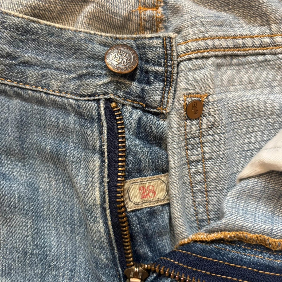 Ralph Lauren blue bootcut jeans with patchwork details and custom "RL" embroidery.