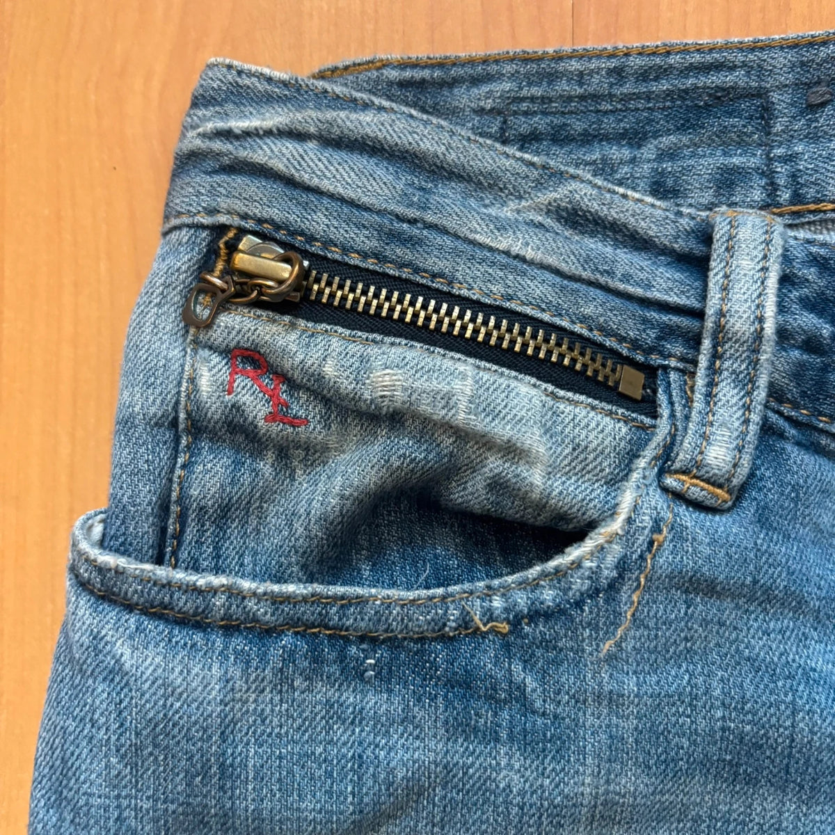 Ralph Lauren blue bootcut jeans with patchwork details and custom "RL" embroidery.