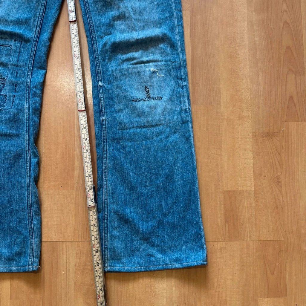 Ralph Lauren blue bootcut jeans with patchwork details and custom "RL" embroidery.