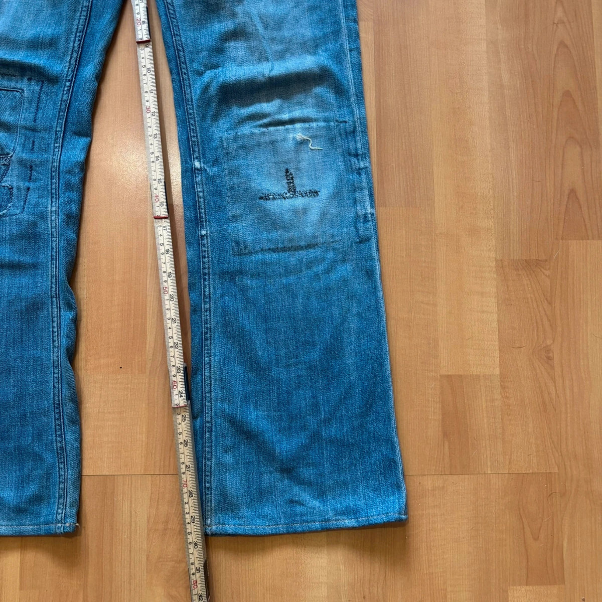Ralph Lauren blue bootcut jeans with patchwork details and custom "RL" embroidery.