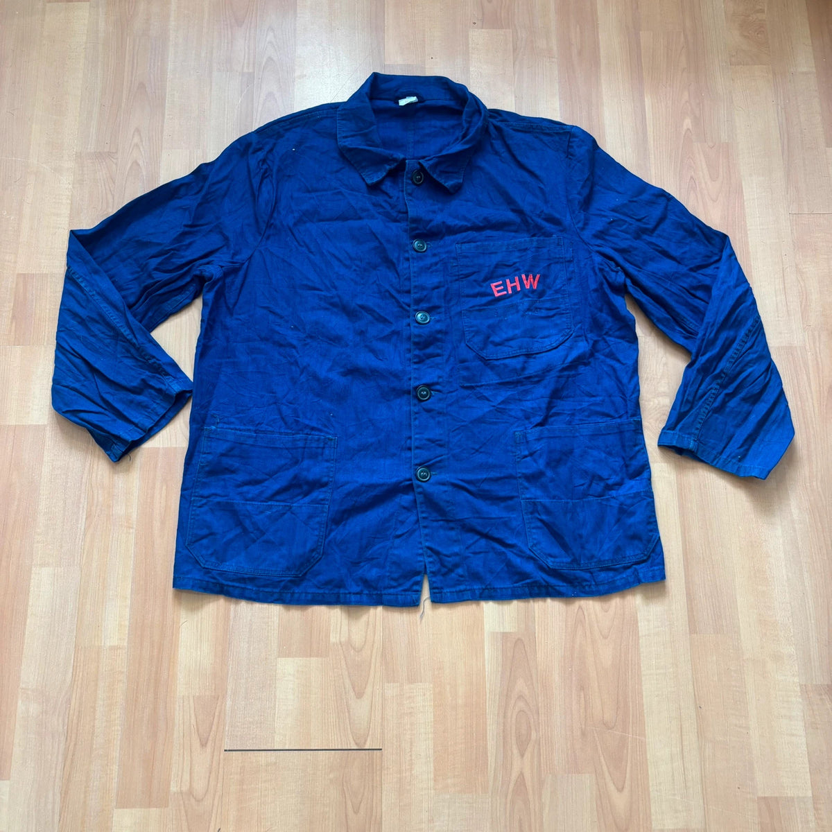 Vintage Dressing navy chore coat with red "EHW" embroidery and classic collar.