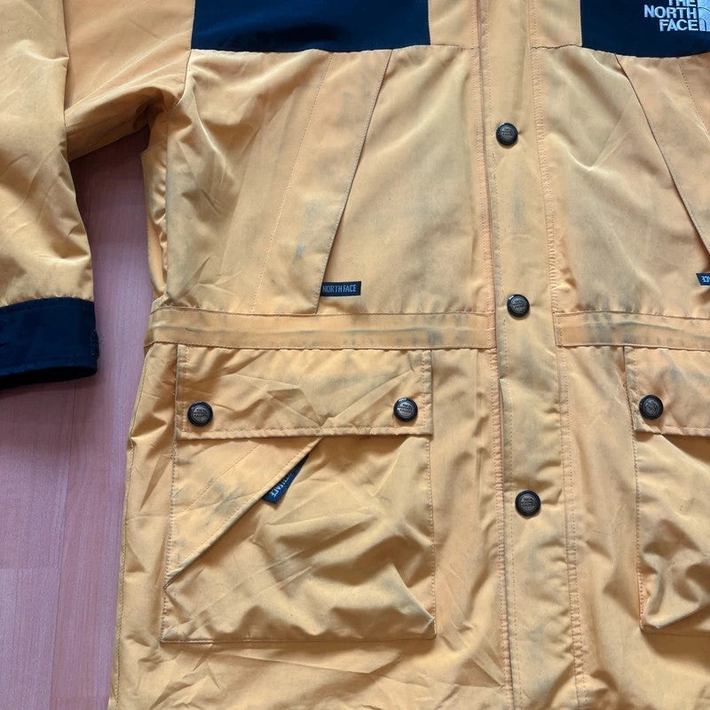 The North Face 2-in-1 jacket yellow black color block design with embroidered logos.