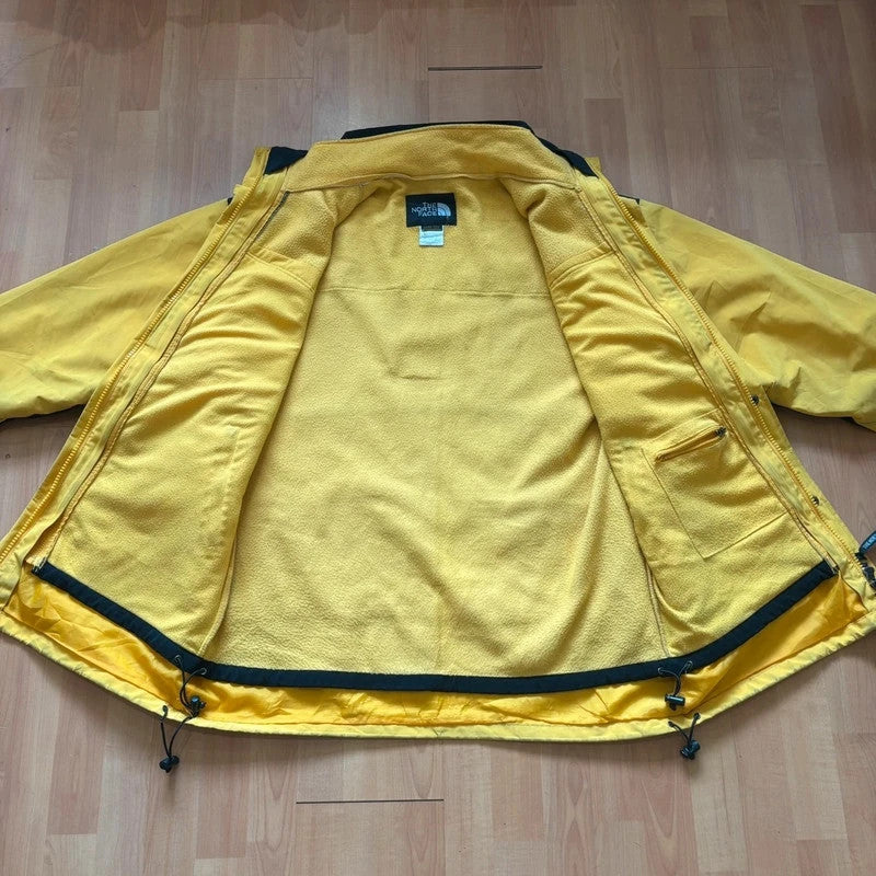 The North Face 2-in-1 jacket yellow black color block design with embroidered logos.