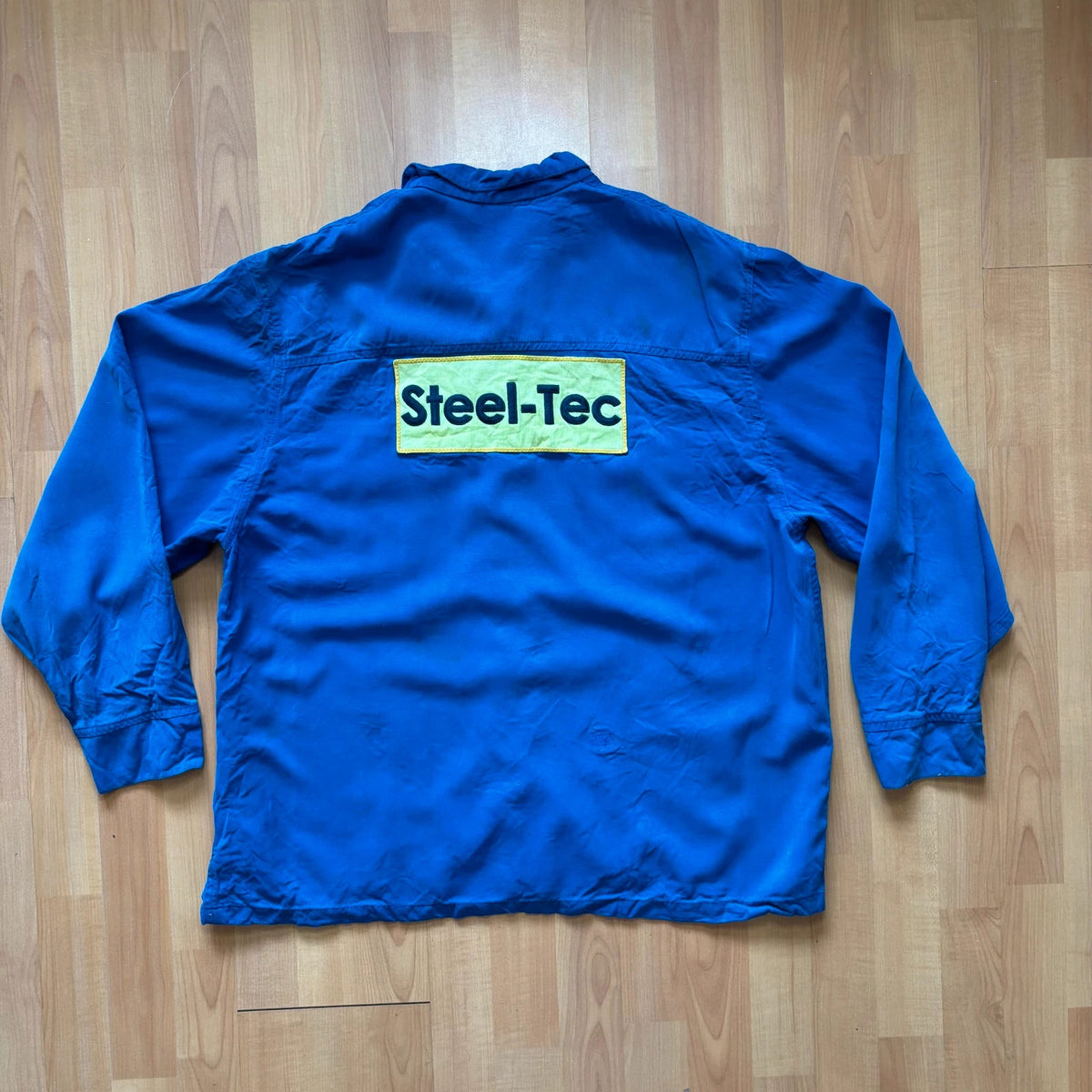 Vintage Dressing blue workwear jacket with snap-button closures and "Steel-Tec" back patch.