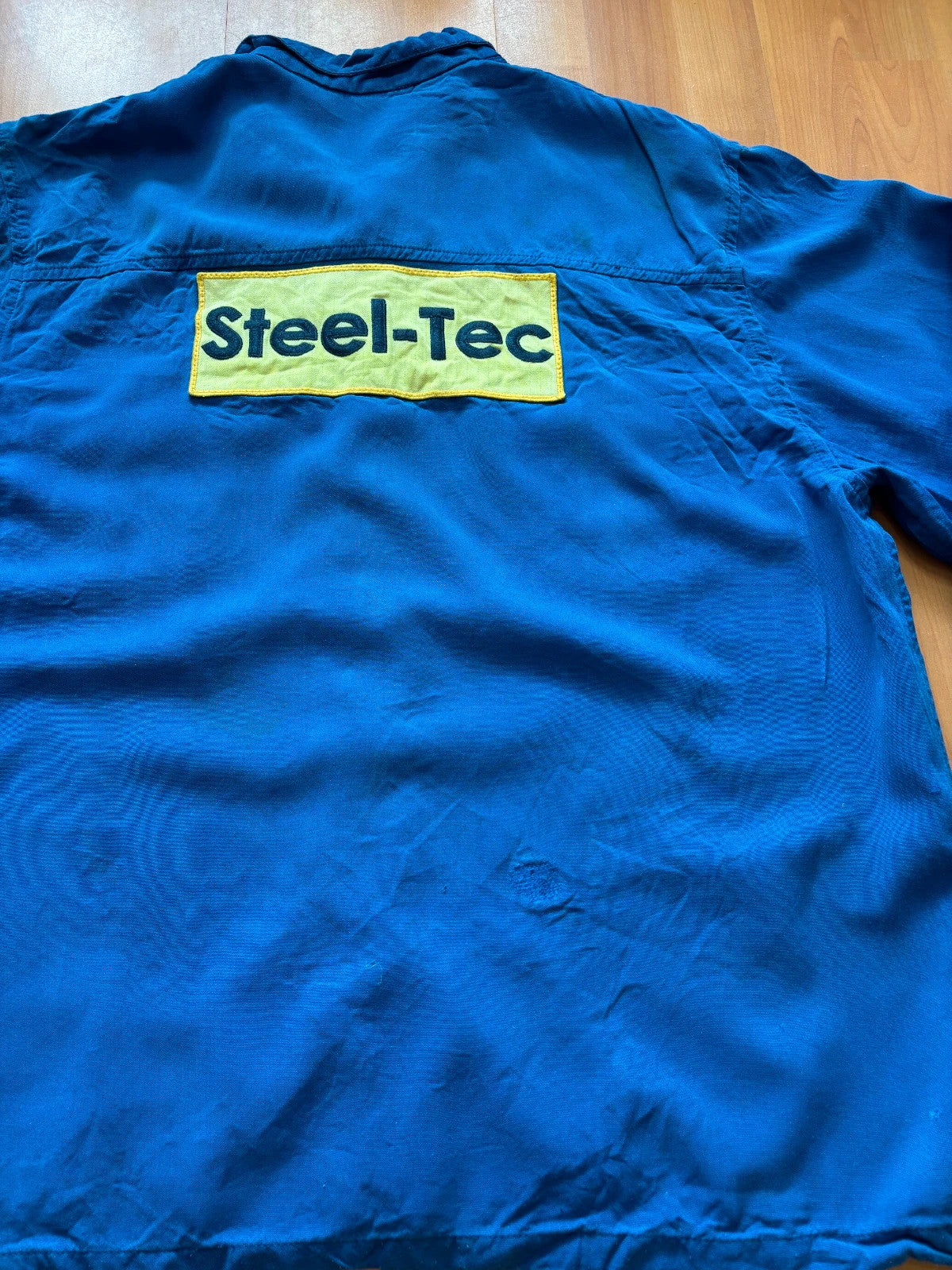 Vintage Dressing blue workwear jacket with snap-button closures and "Steel-Tec" back patch.