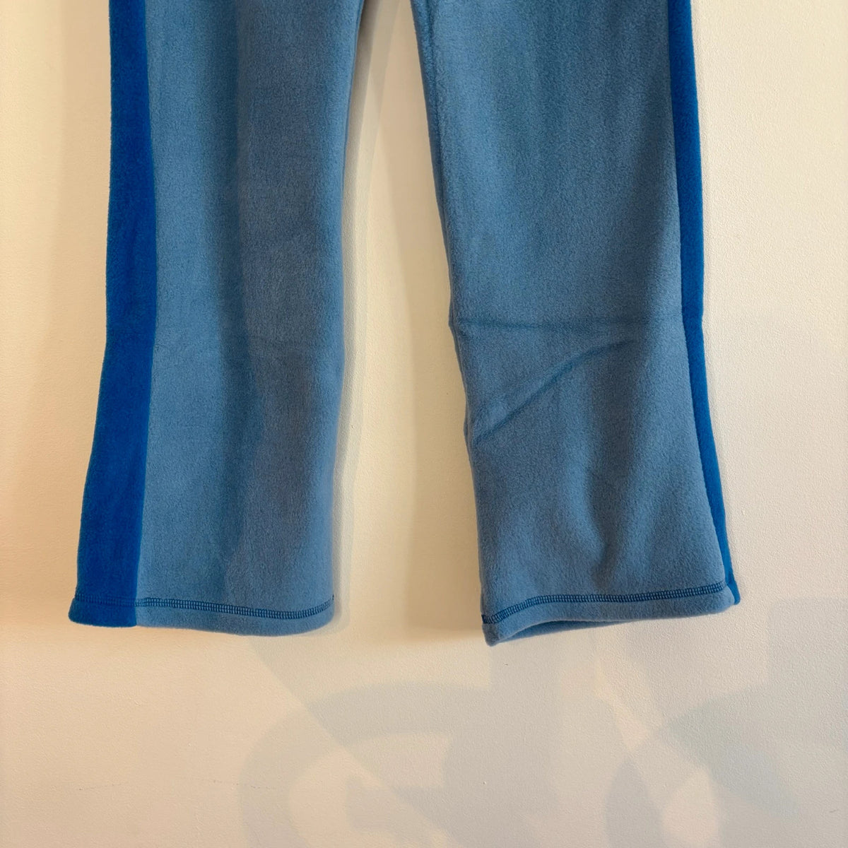 DKNY blue fleece tracksuit set with logo branding and side stripe details.
