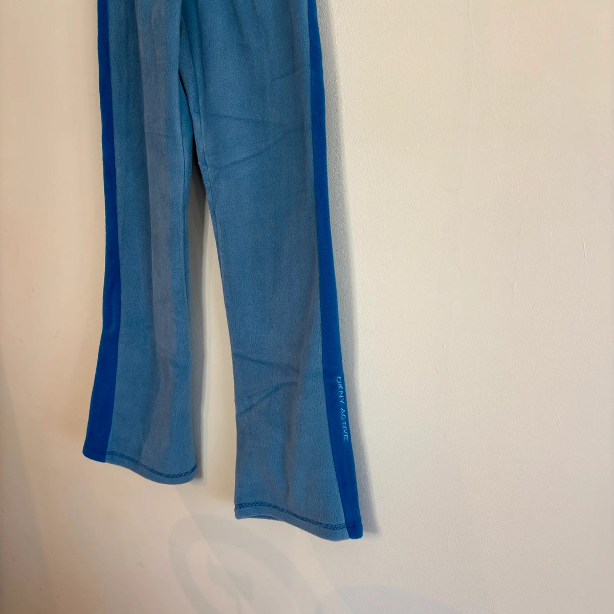 DKNY blue fleece tracksuit set with logo branding and side stripe details.