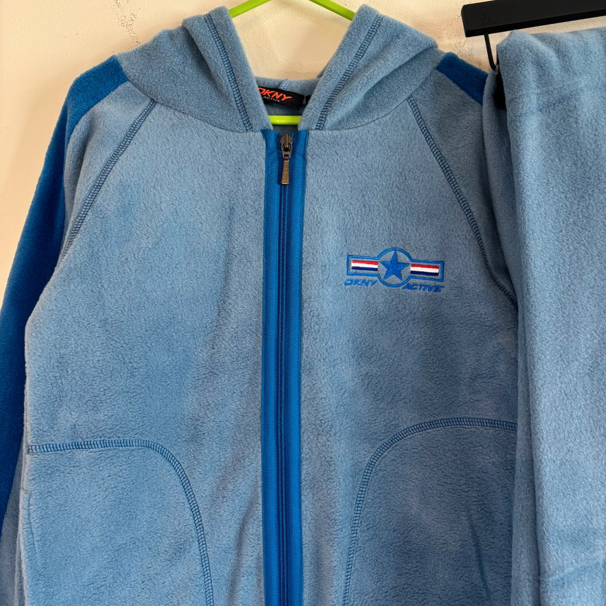 DKNY blue fleece tracksuit set with logo branding and side stripe details.