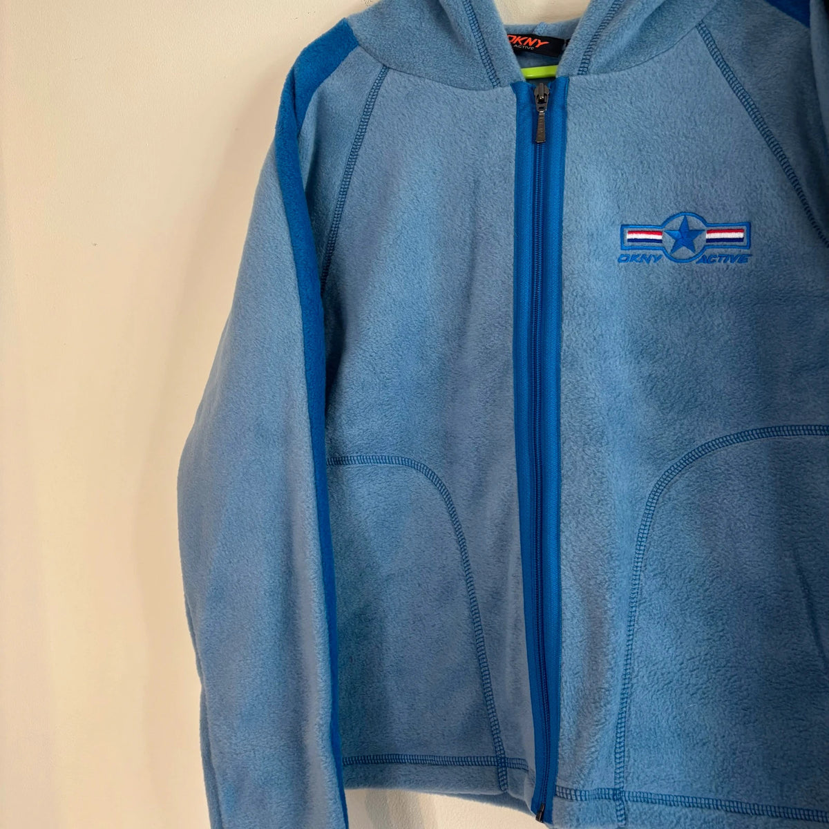 DKNY blue fleece tracksuit set with logo branding and side stripe details.