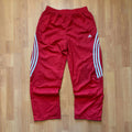 Adidas red joggers with white three-stripe detailing and adjustable drawstring waist.