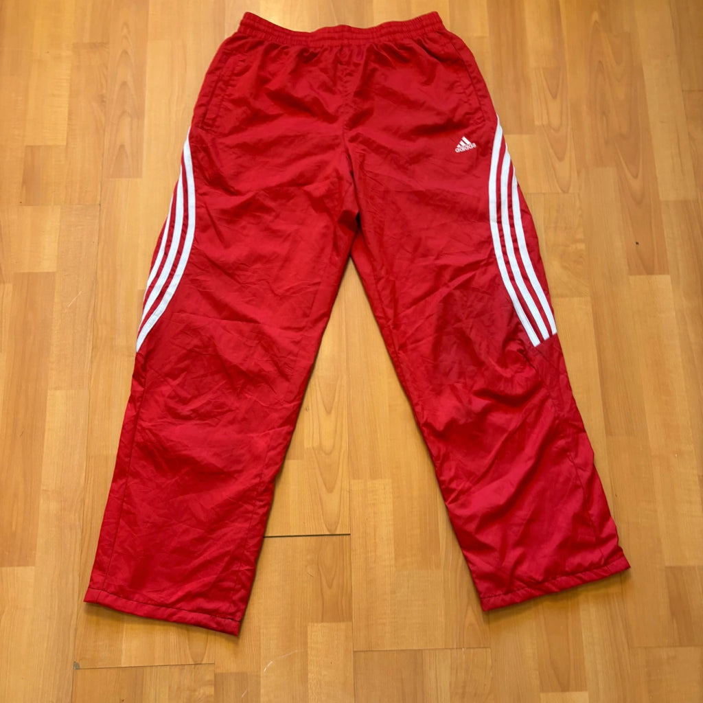 Adidas red joggers with white three-stripe detailing and adjustable drawstring waist.