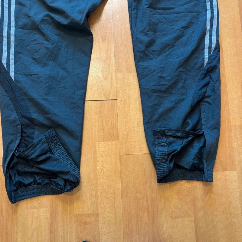 Adidas grey joggers with reflective three-stripe detailing and adjustable drawstring waist.
