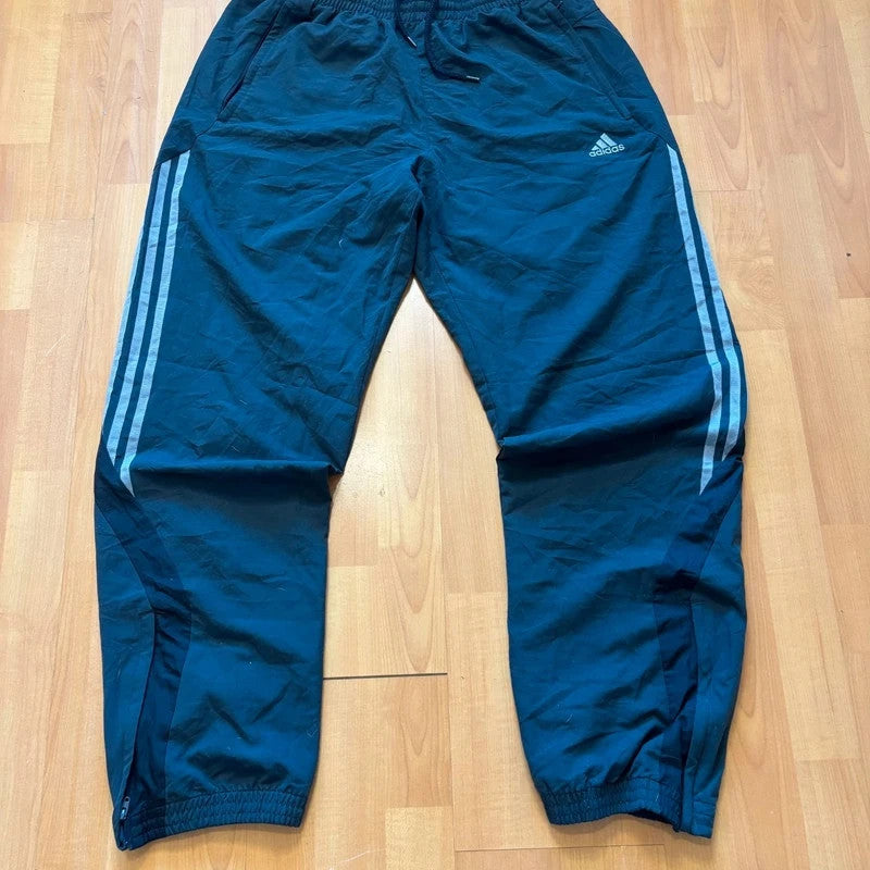 Adidas grey joggers with reflective three-stripe detailing and adjustable drawstring waist.