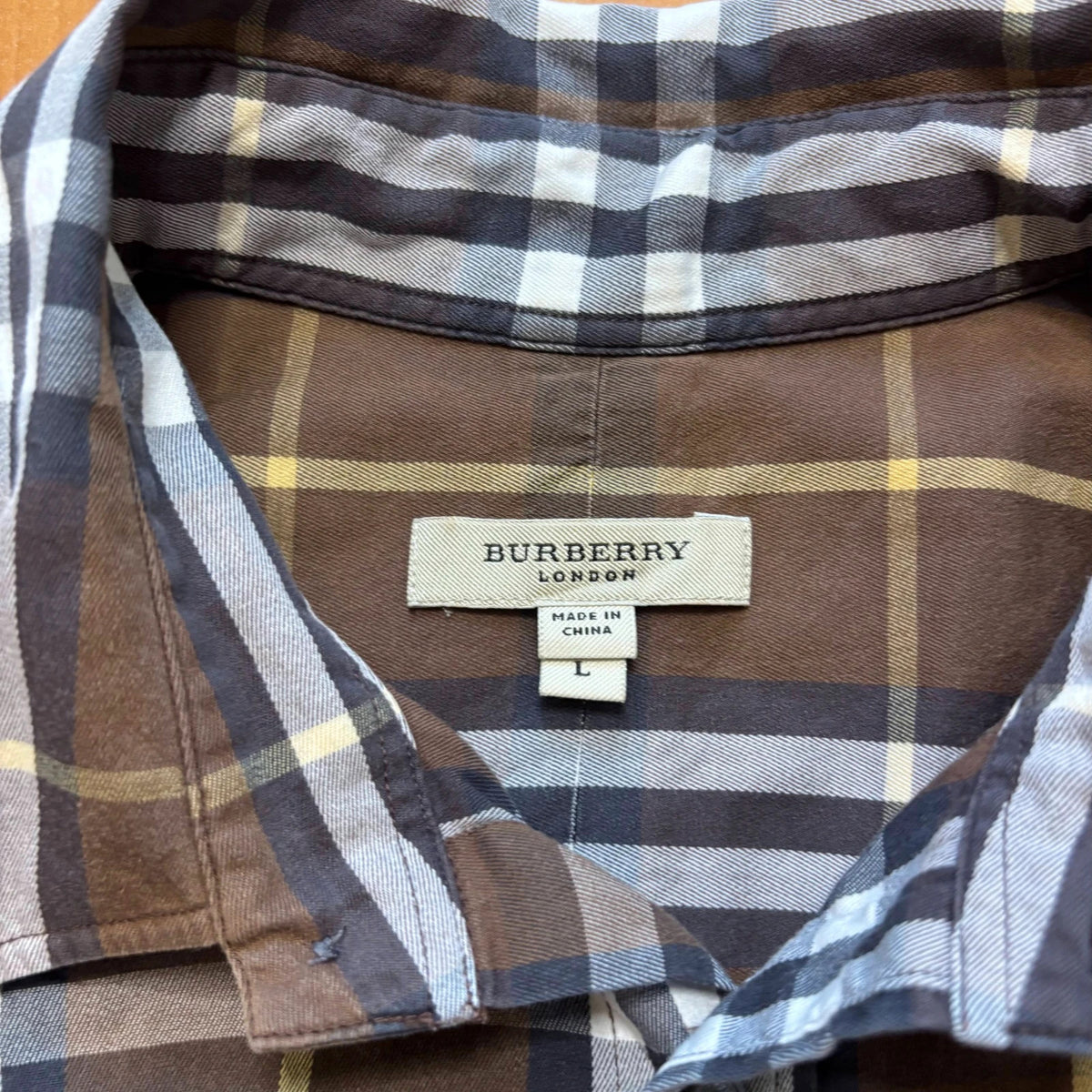 Burberry men's button-up shirt blue and brown plaid with knight logo embroidered on chest.