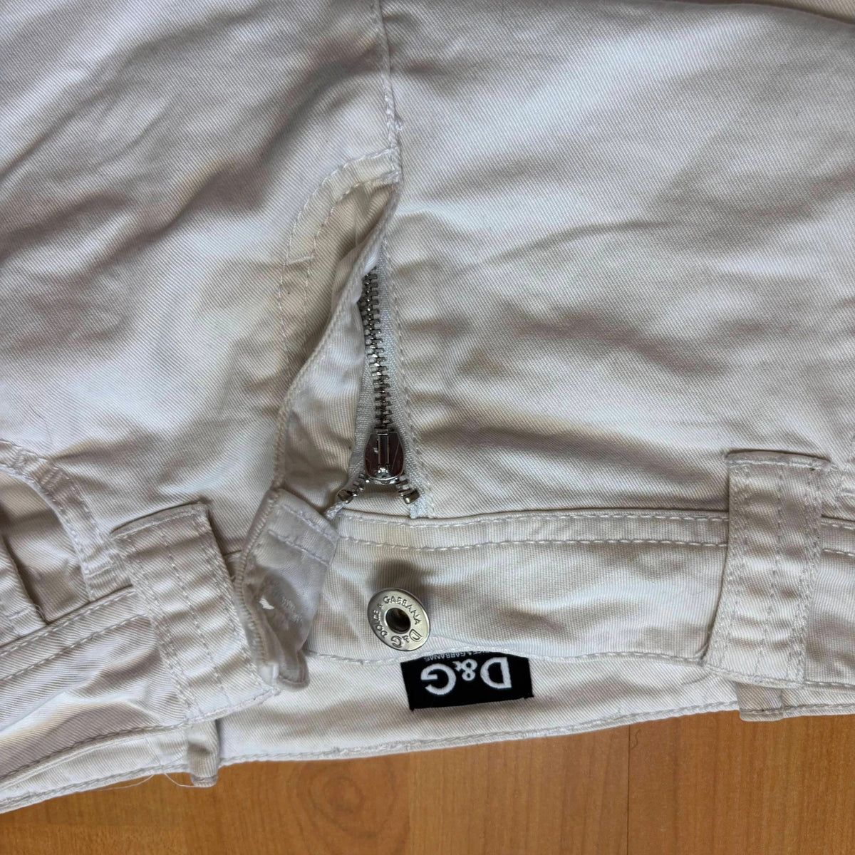 Dolce & Gabbana white denim mini skirt with utility pockets and branded hardware.
