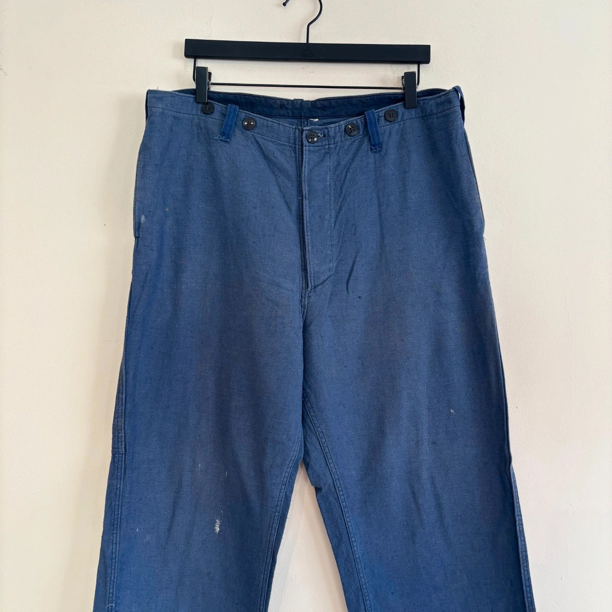 Reclaimed Vintage blue wide-leg trousers with button fly and side tool pocket accents.