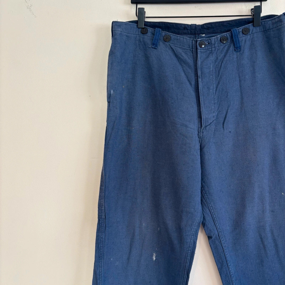 Reclaimed Vintage blue wide-leg trousers with button fly and side tool pocket accents.