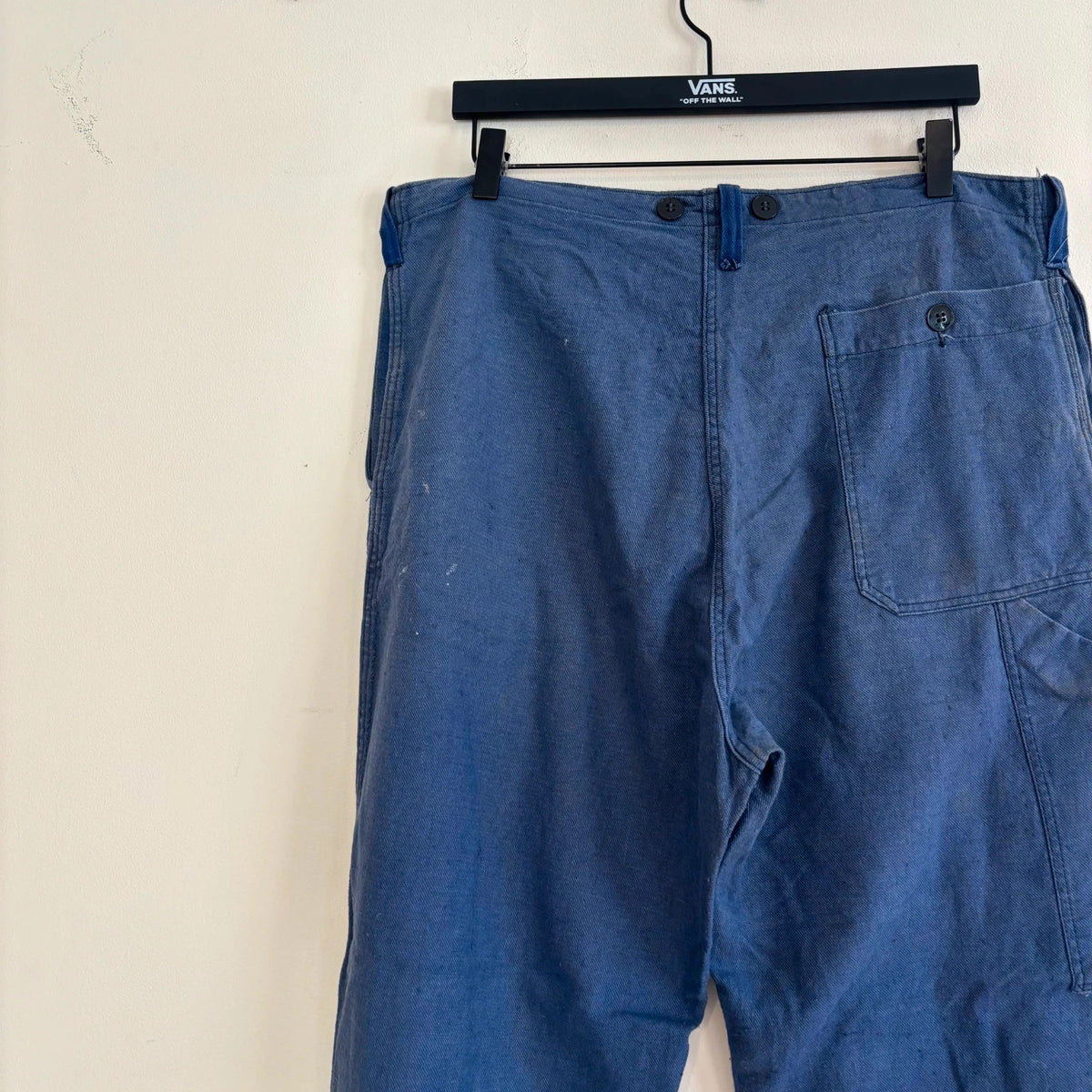 Reclaimed Vintage blue wide-leg trousers with button fly and side tool pocket accents.