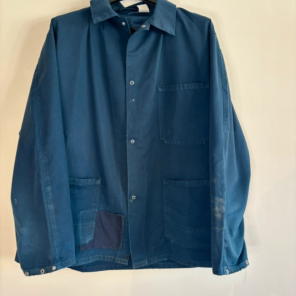 Vintage Dressing navy chore jacket with snap buttons, utility pockets, and patch repair detail.