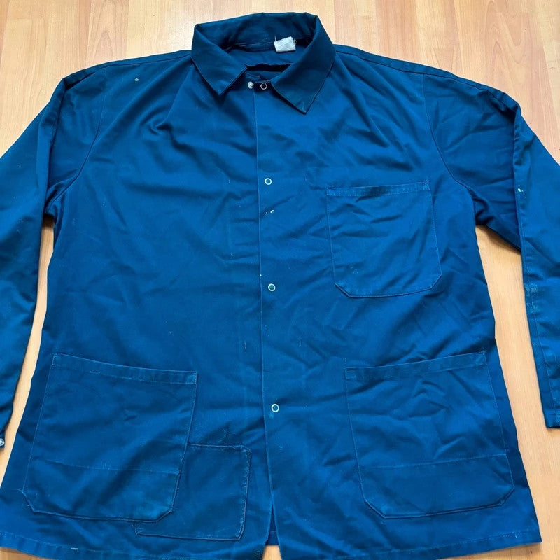 Vintage Dressing navy chore jacket with snap buttons, utility pockets, and patch repair detail.