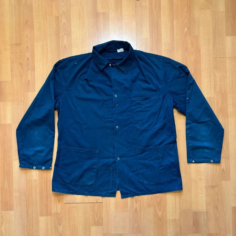Vintage Dressing navy chore jacket with snap buttons, utility pockets, and patch repair detail.
