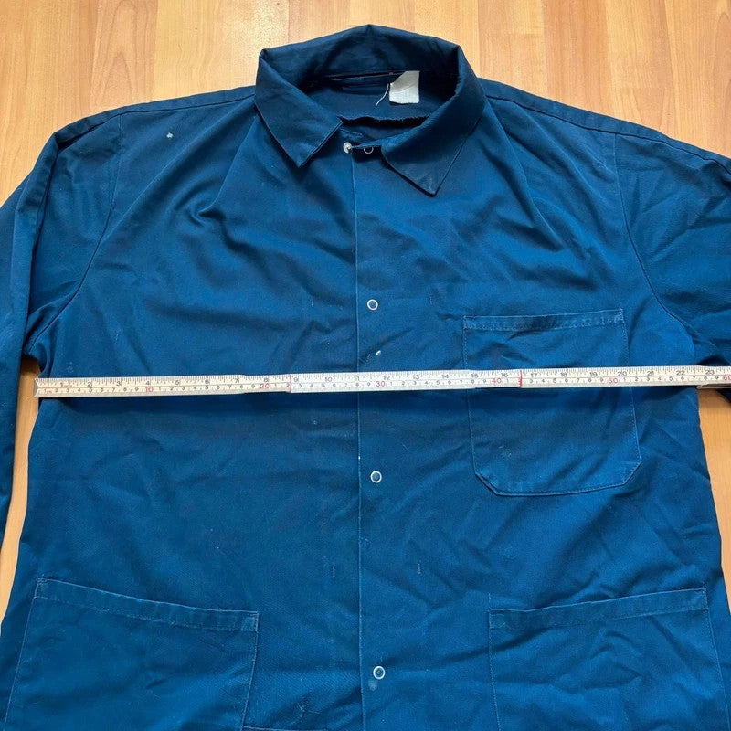 Vintage Dressing navy chore jacket with snap buttons, utility pockets, and patch repair detail.
