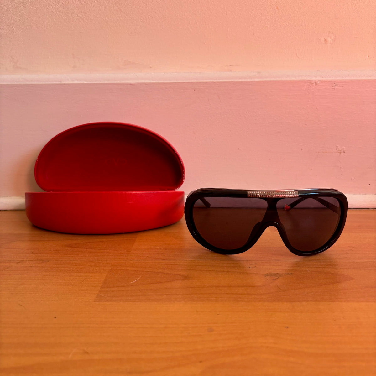 Valentino black sunglasses with rhinestone detailing and red hard case featuring logo.