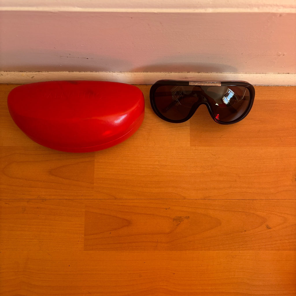 Valentino black sunglasses with rhinestone detailing and red hard case featuring logo.