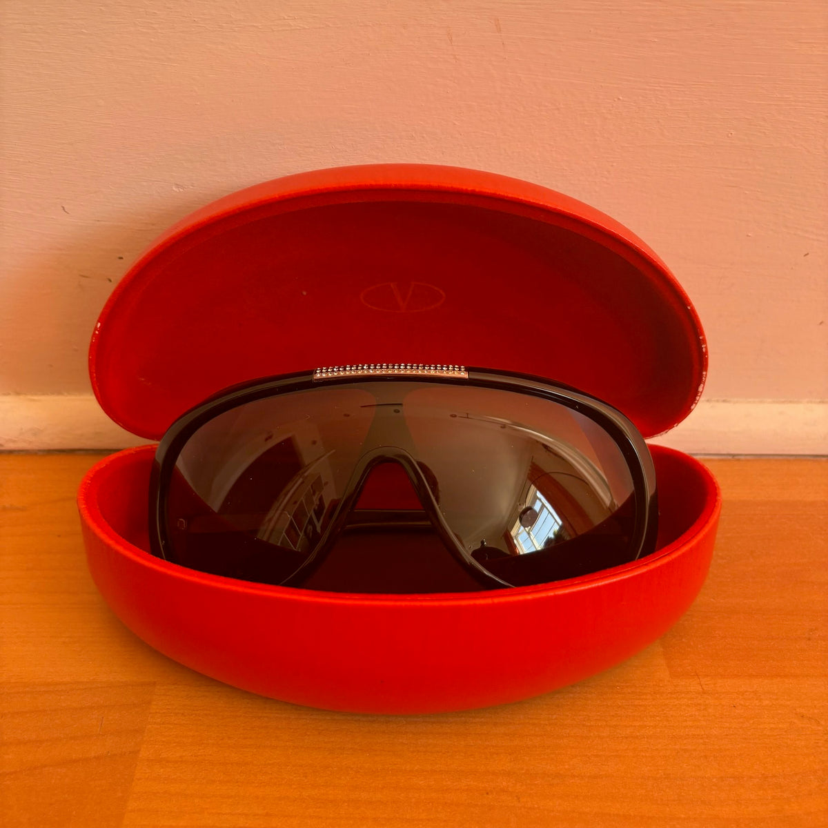 Valentino black sunglasses with rhinestone detailing and red hard case featuring logo.