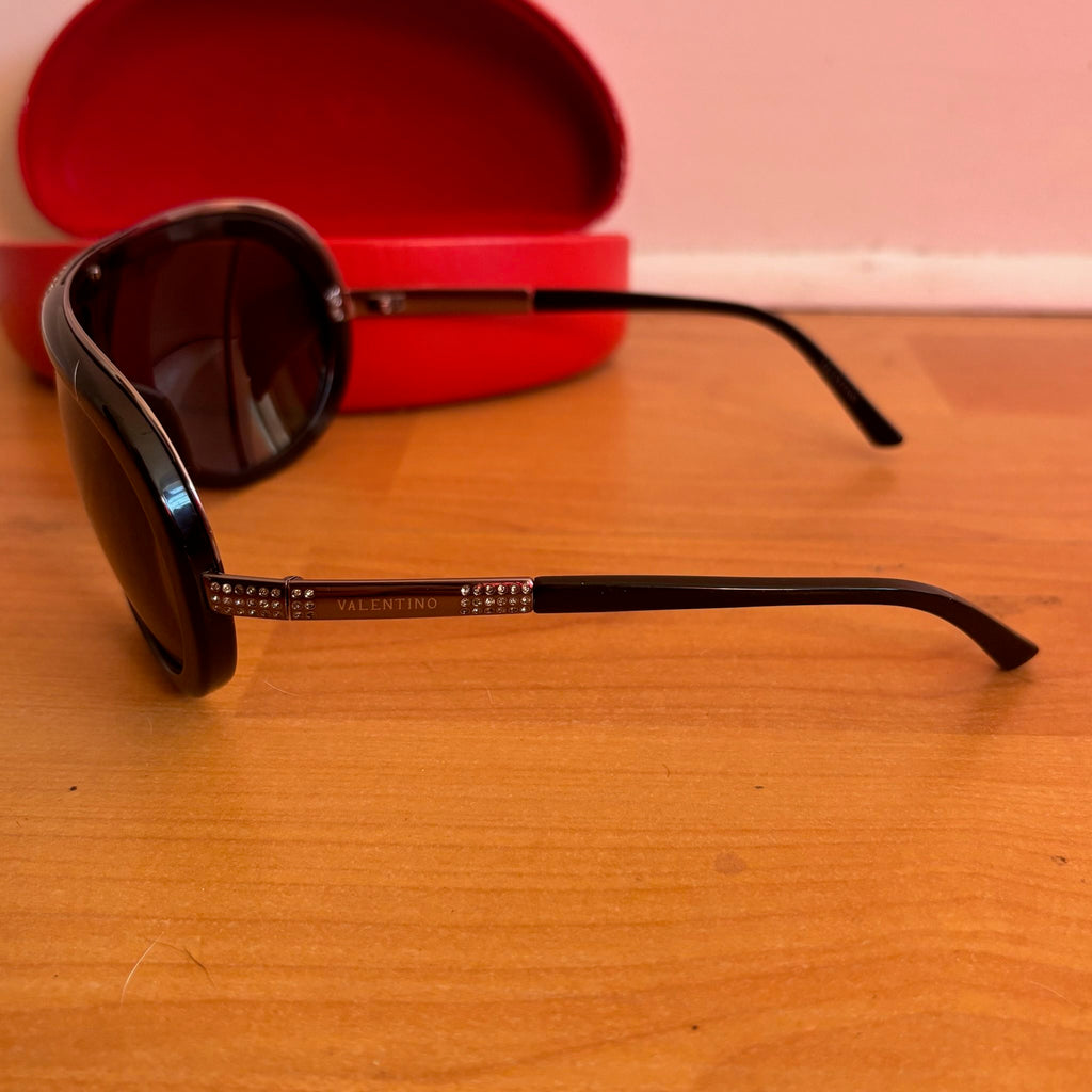 Valentino black sunglasses with rhinestone detailing and red hard case featuring logo.