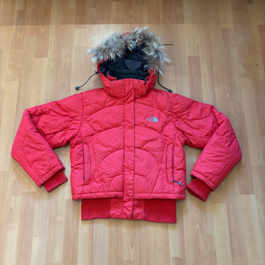 The North Face red down jacket with faux fur hood, ribbed cuffs, and zip pockets.