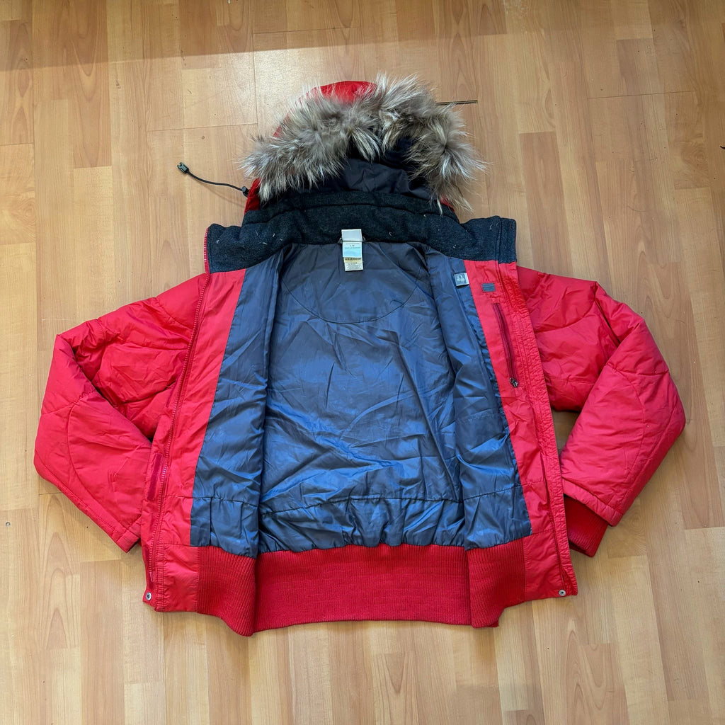 The North Face red down jacket with faux fur hood, ribbed cuffs, and zip pockets.