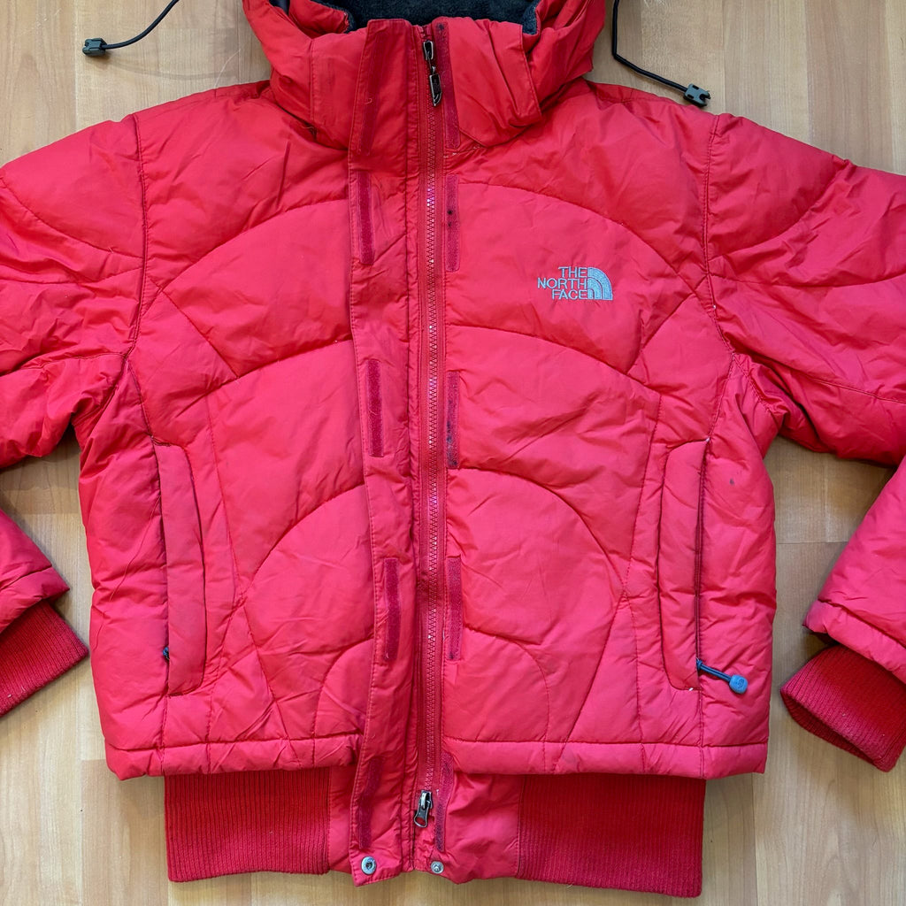 The North Face red down jacket with faux fur hood, ribbed cuffs, and zip pockets.