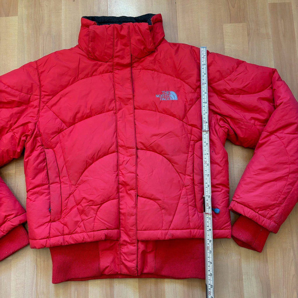 The North Face red down jacket with faux fur hood, ribbed cuffs, and zip pockets.