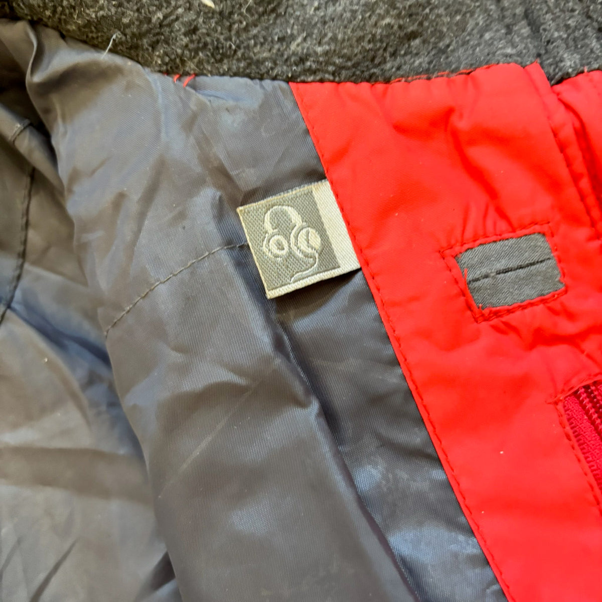 The North Face red down jacket with faux fur hood, ribbed cuffs, and zip pockets.