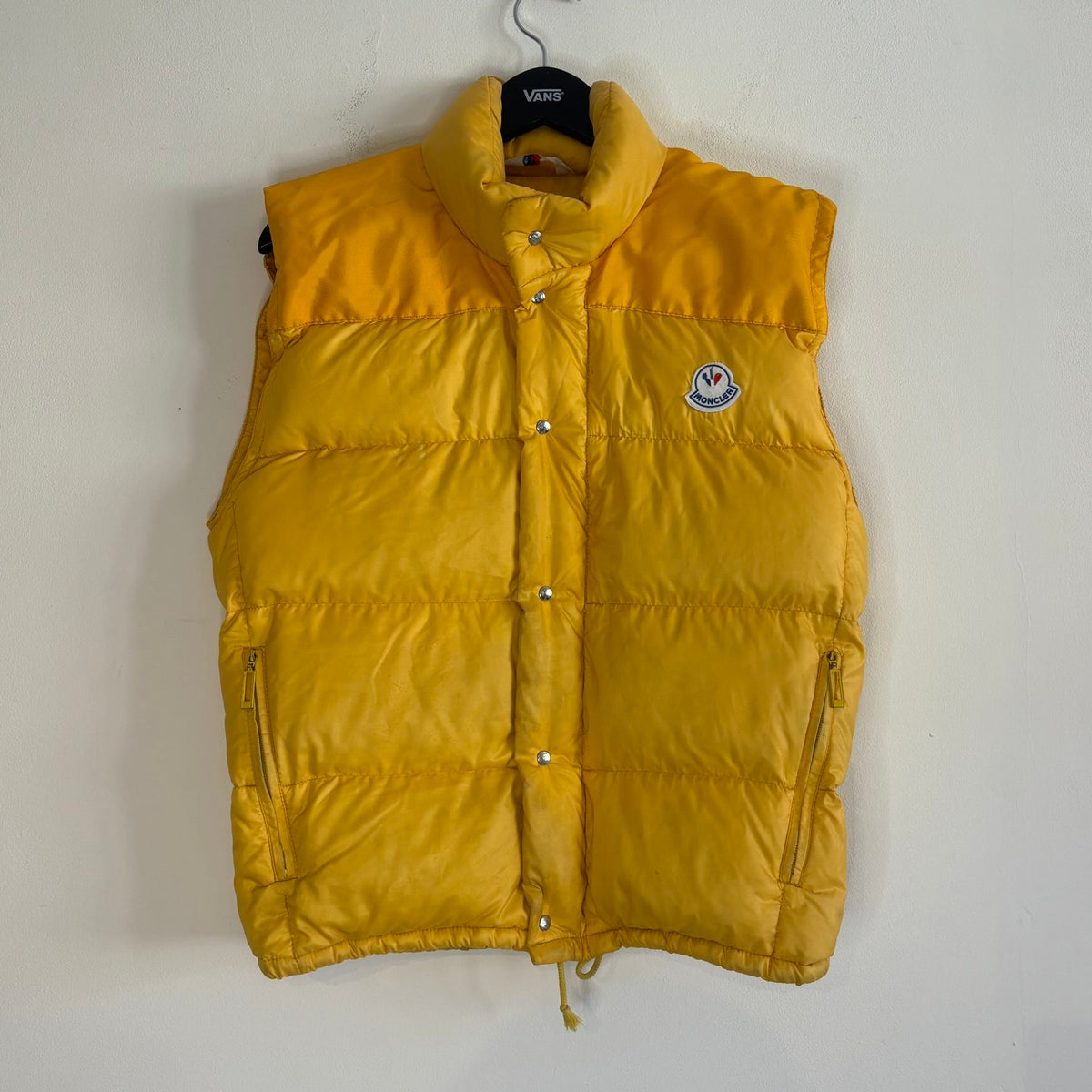 Moncler yellow down gilet vest with snap-button placket and zip pockets, made in France.