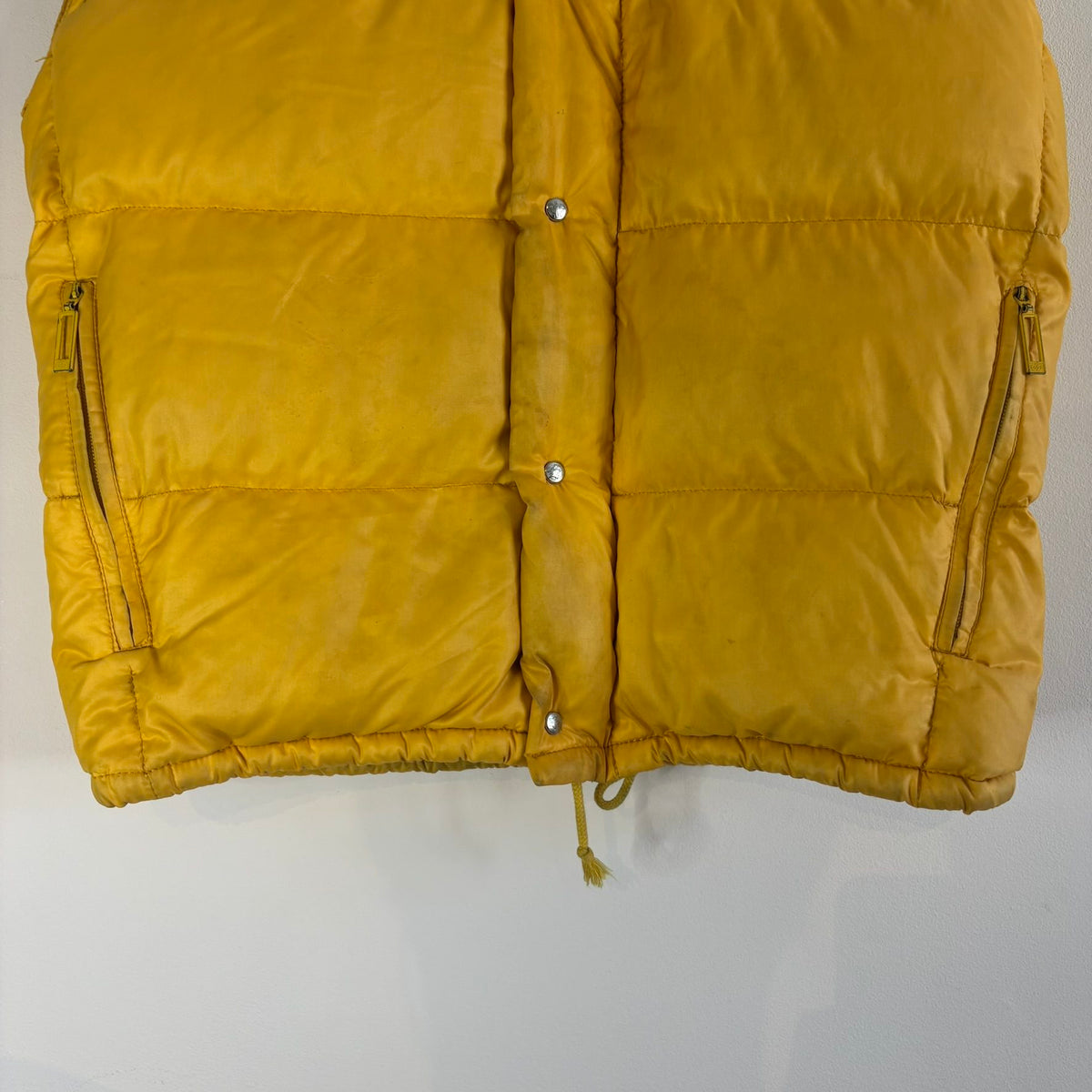 Moncler yellow down gilet vest with snap-button placket and zip pockets, made in France.