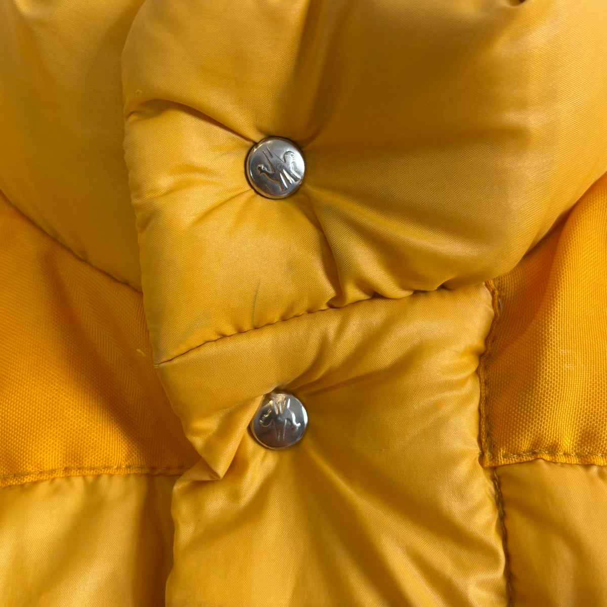 Moncler yellow down gilet vest with snap-button placket and zip pockets, made in France.