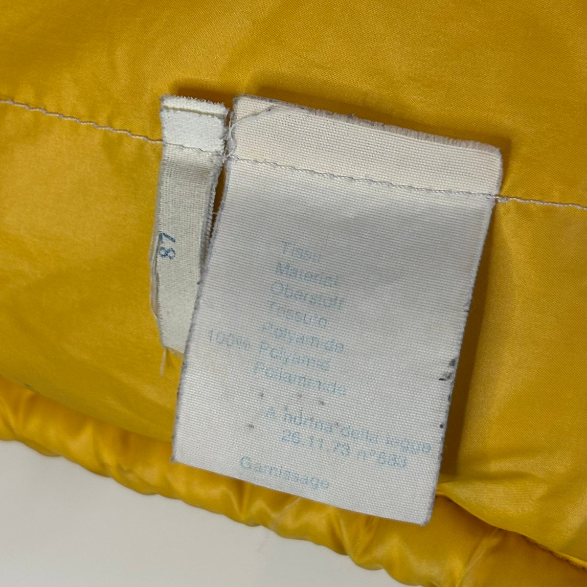 Moncler yellow down gilet vest with snap-button placket and zip pockets, made in France.