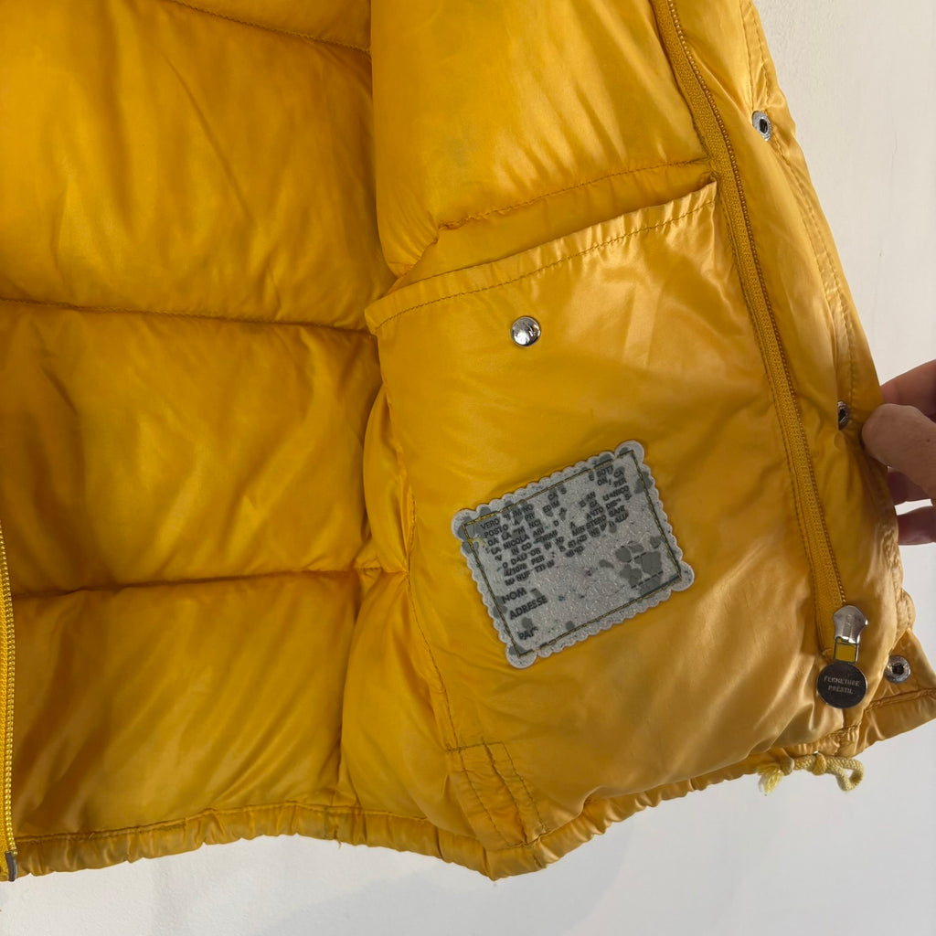 Moncler yellow down gilet vest with snap-button placket and zip pockets, made in France.