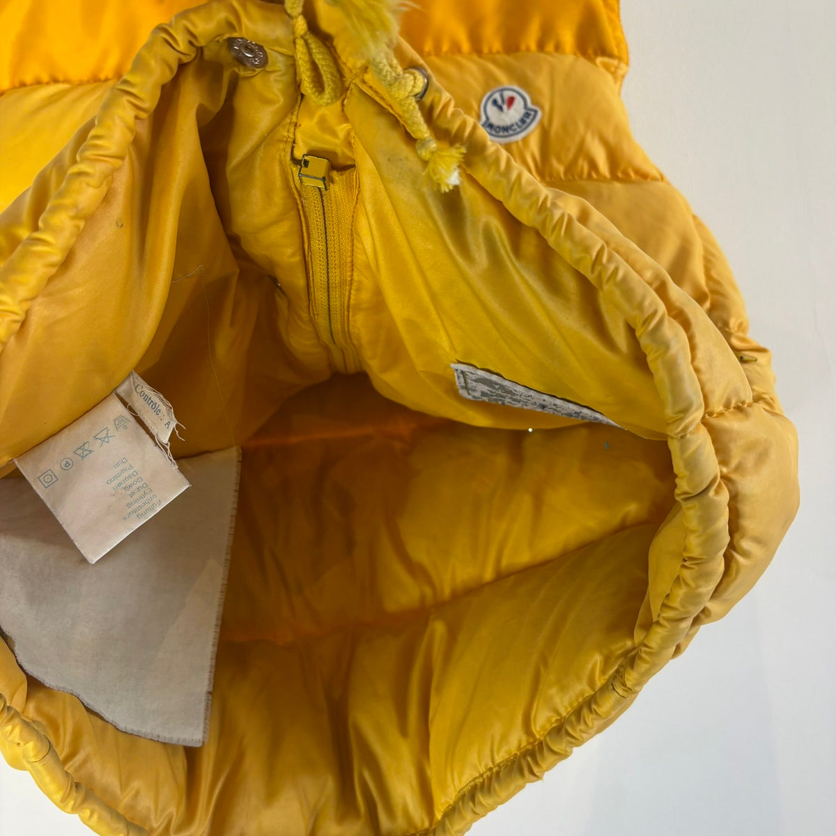 Moncler yellow down gilet vest with snap-button placket and zip pockets, made in France.