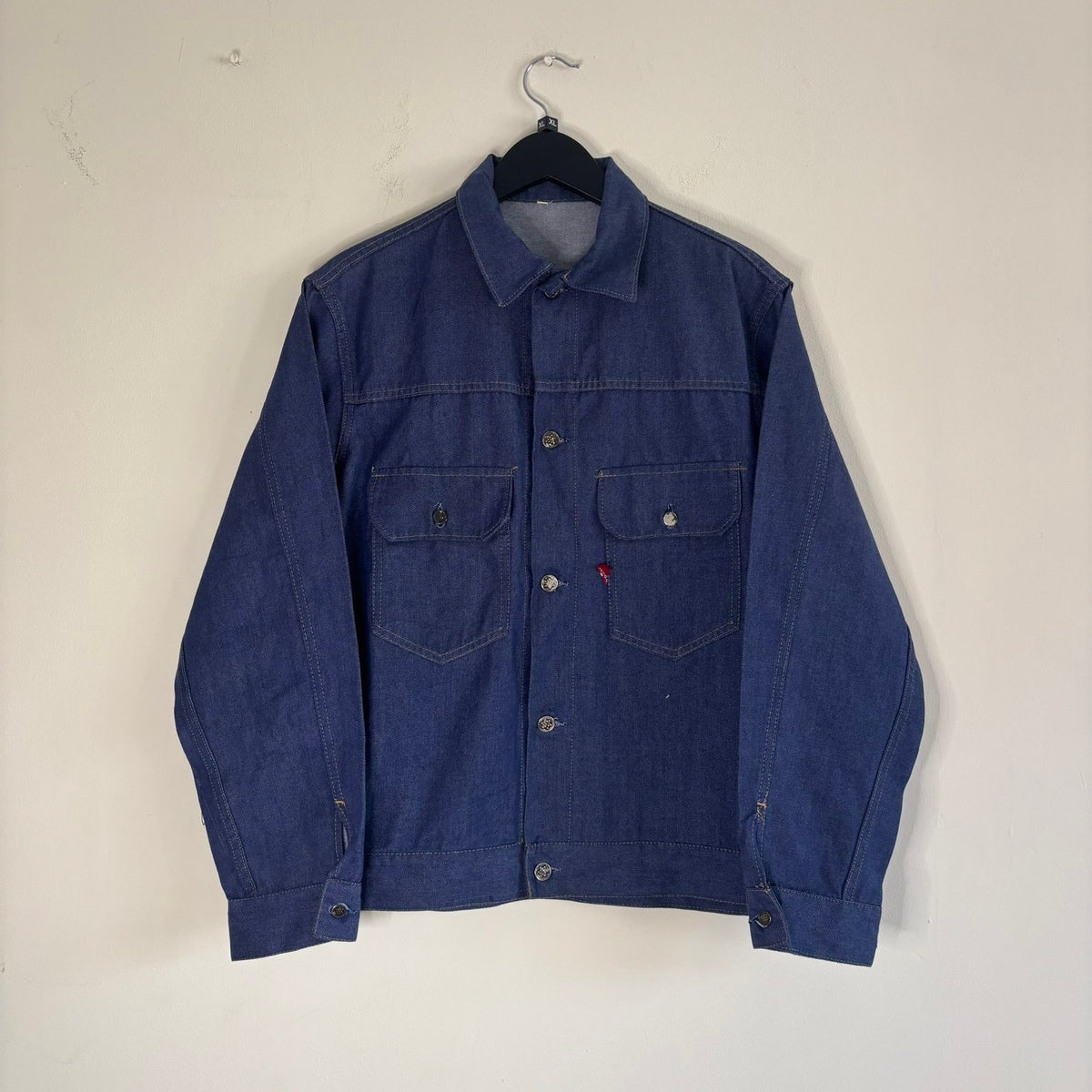 Vétra blue denim jacket with gold stitching, star-embossed buttons, and red logo tab.