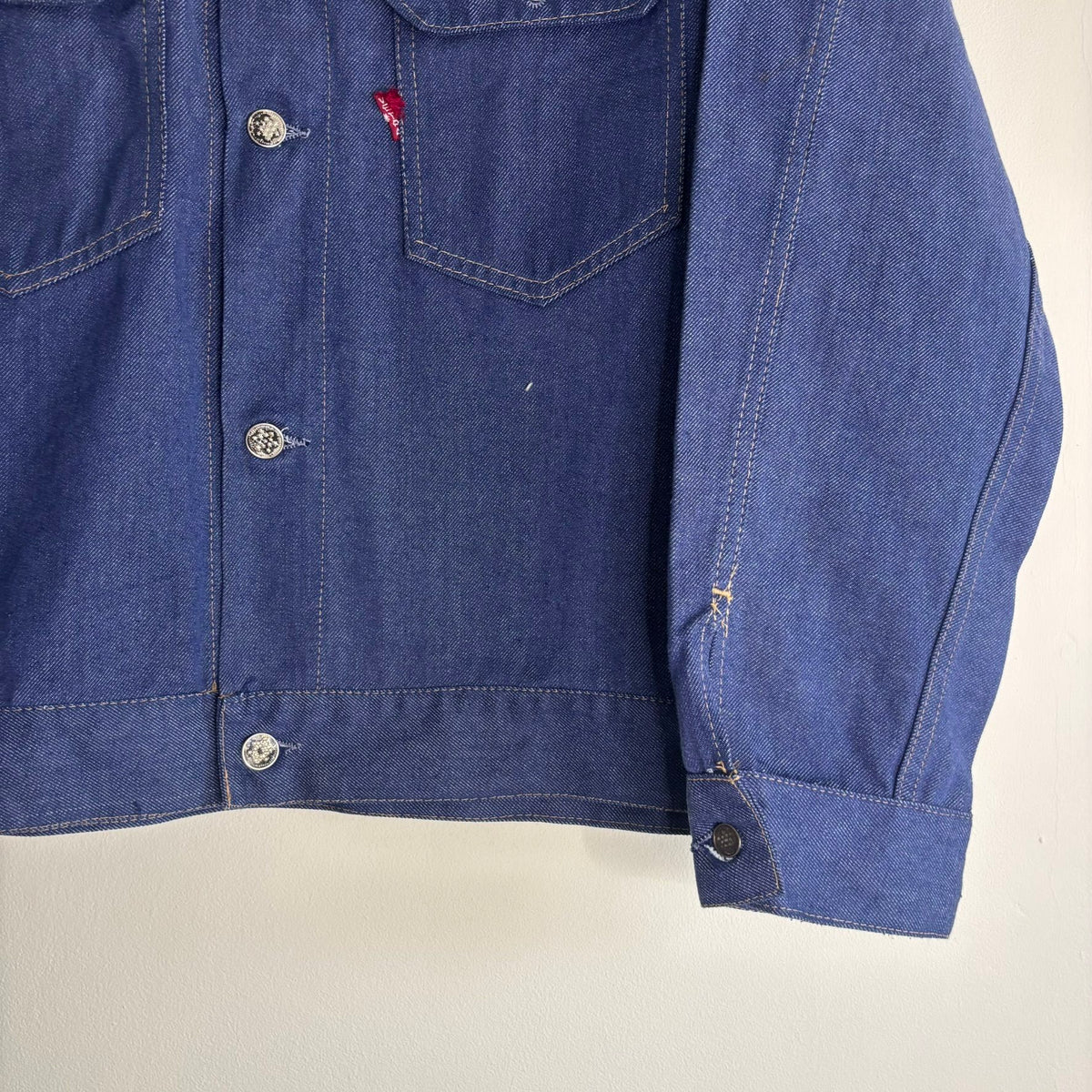 Vétra blue denim jacket with gold stitching, star-embossed buttons, and red logo tab.
