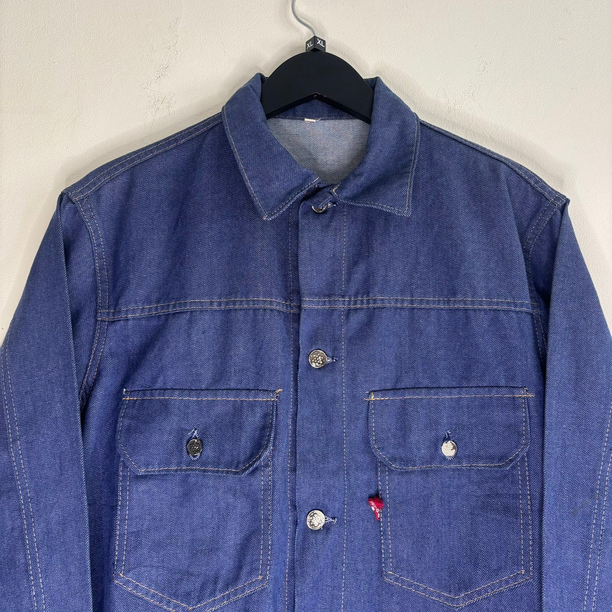 Vétra blue denim jacket with gold stitching, star-embossed buttons, and red logo tab.