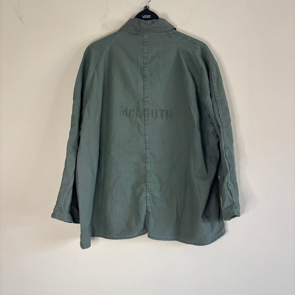 Vintage green cotton work jacket with snap front and stencilled "McLOUTH" on back.