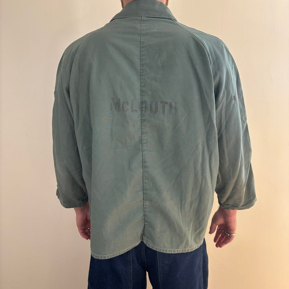 Vintage green cotton work jacket with snap front and stencilled "McLOUTH" on back.